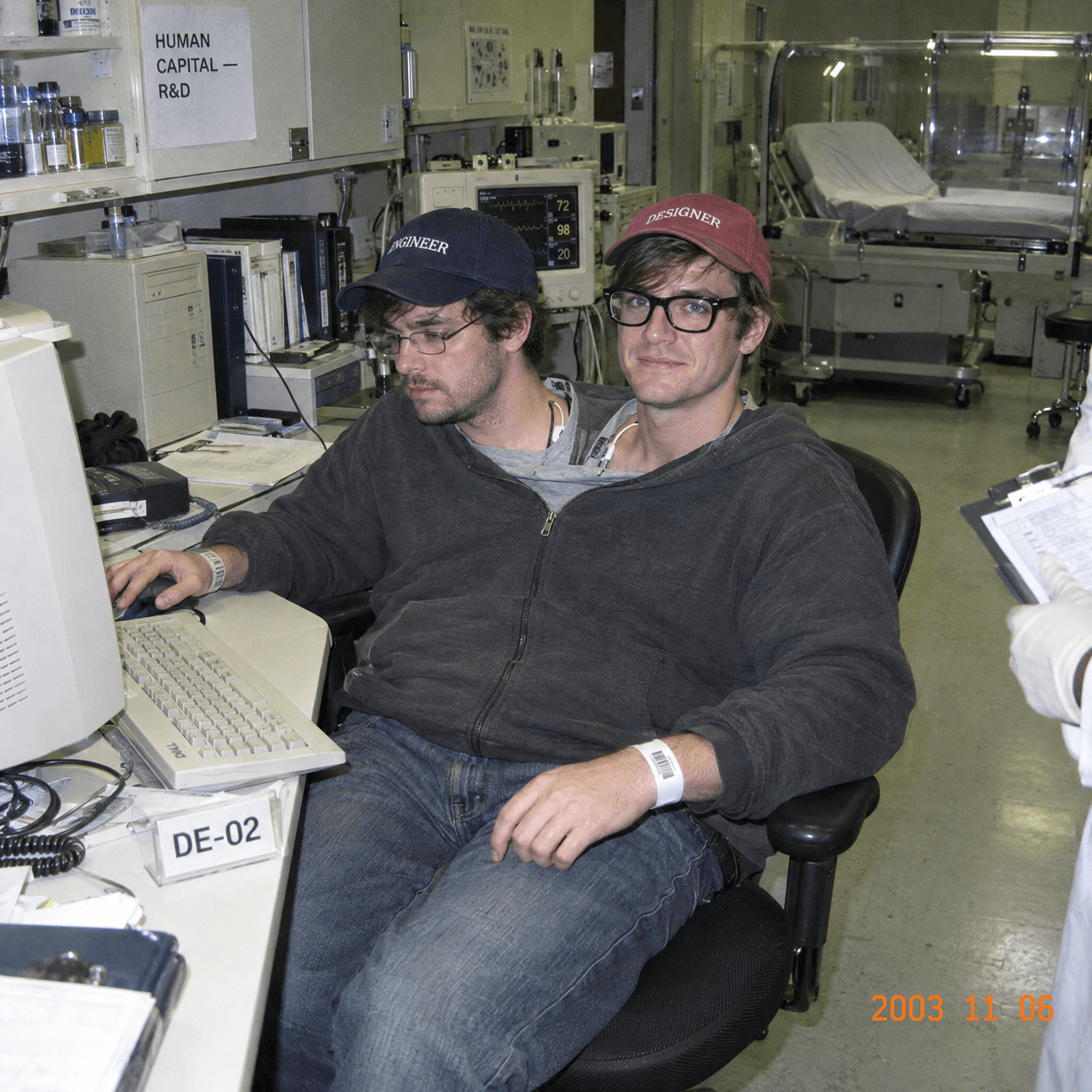 A FullStack Genetics engineer-designer placement at a shared workstation, wearing caps labeled “Engineer” and “Designer.”